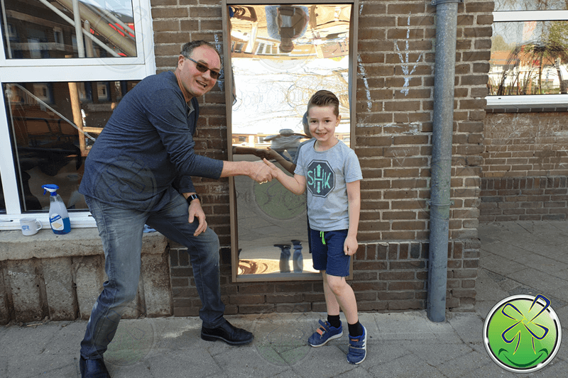 Overhandiging van de lachspiegel aan Bennie. Als service hebben wij hem ook nog even opgehangen.